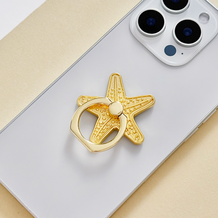 Silver smartphone with a Coconut Lane adhesive phone ring featuring a starfish design.