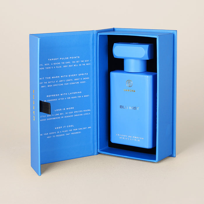 Front of Blu Mist perfume in open blue gift box showing rectangular bottle with matching cap on beige background