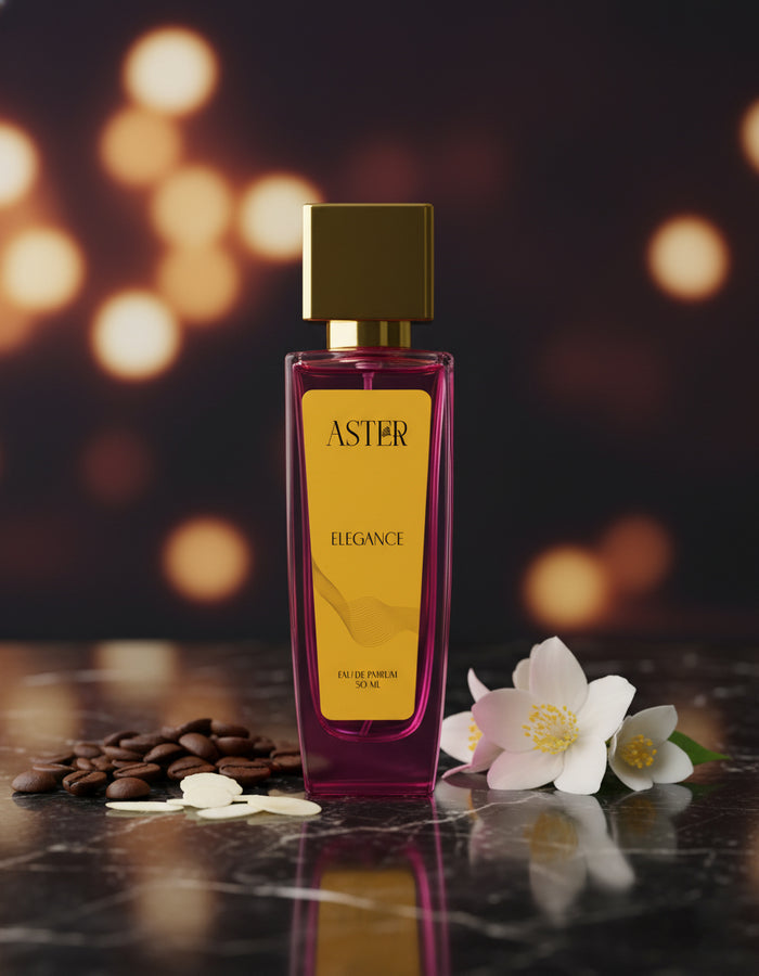 Perfume bottle labeled 'Aster' with flowers and coffee beans on a dark surface with blurred lights in the background