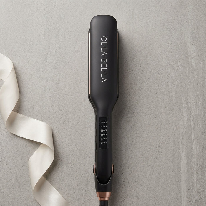 An Olla Bella 2" Wide Plate Hair Straightener on a textured gray background with a white ribbon on the left side.