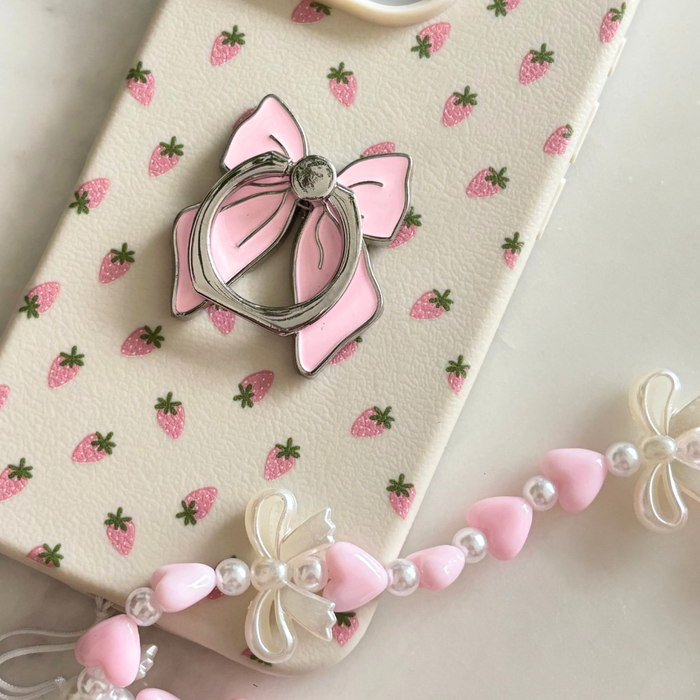 Coconut Lane pink bow phone ring holder with a matching beaded charm featuring pink hearts and bows.
