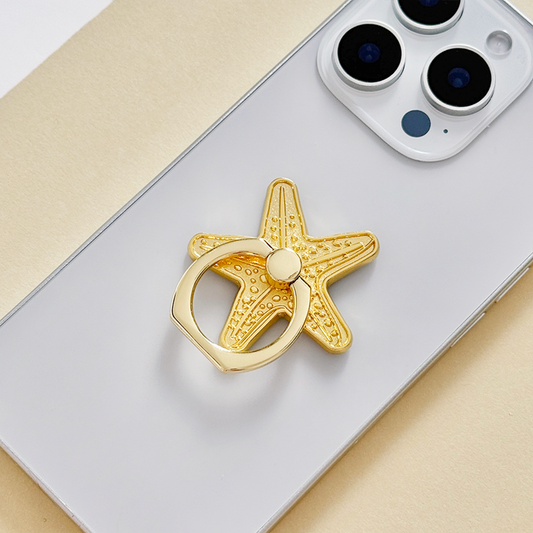Silver smartphone with a Coconut Lane adhesive phone ring featuring a starfish design.