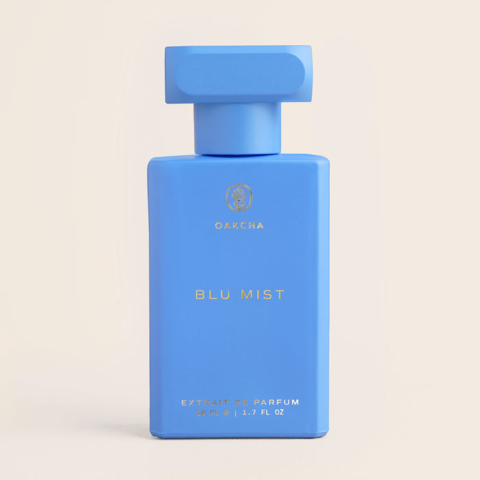 Front view of Blu Mist perfume bottle showing matte blue rectangular bottle with oversized matching cap on pale beige background