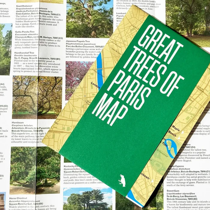 Cover of the Blue Crow Media Great Trees Of Paris Map, featuring a green band and a partial view of a yellow map in the background, printed on recycled paper.