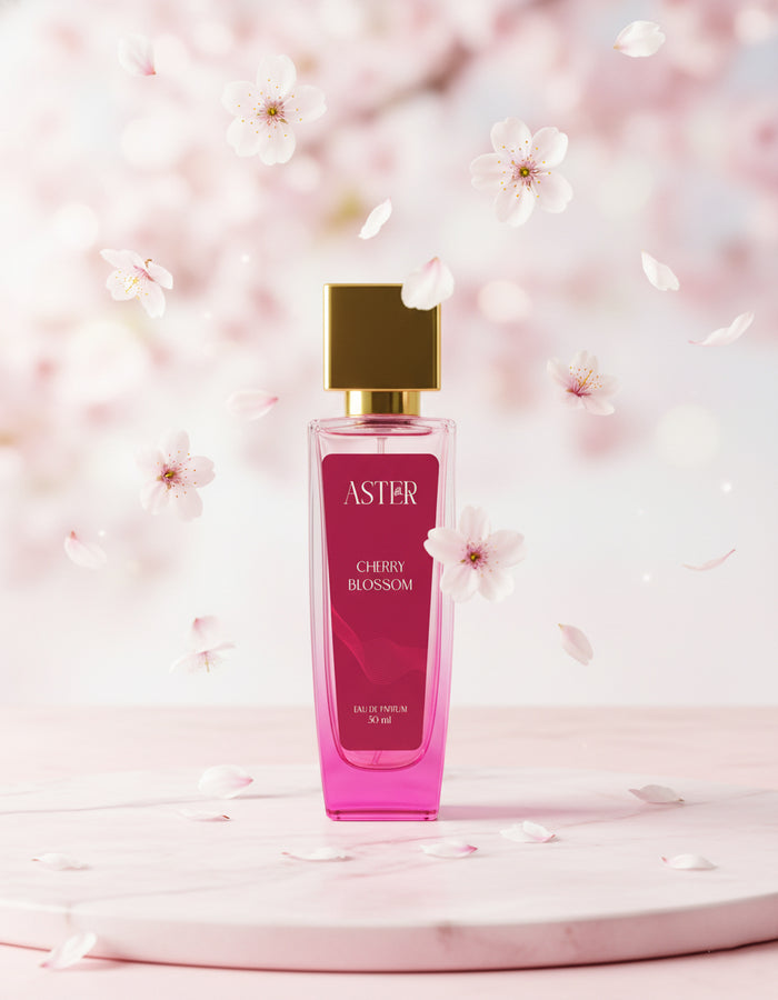 Perfume bottle labeled 'ASTER Cherry Blossom' on a pink floral background