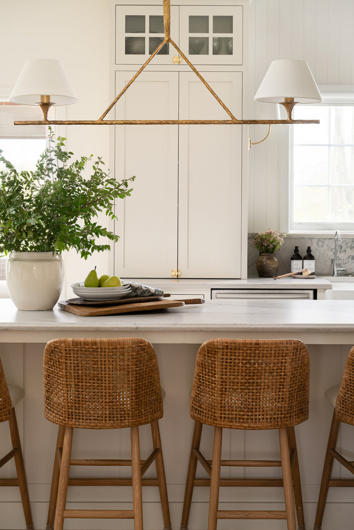 White ceramic pot with two small handles on each side styled on a kitchen counter with greenery. The smooth, glossy surface and wide opening give a simple, elegant appearance. | Wildwood Home Co.