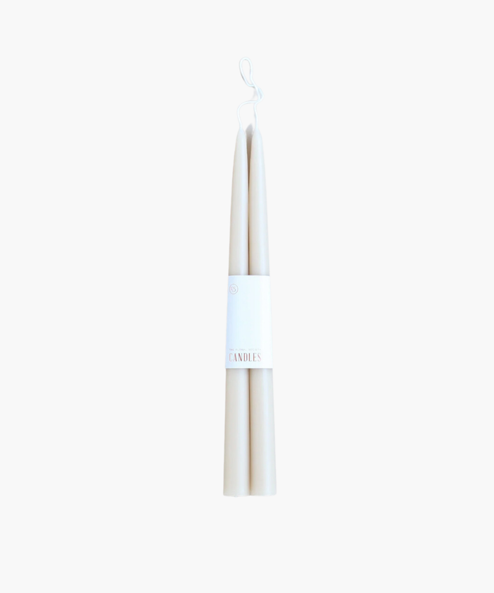 Two white tapered candles with a simple label reading "Candles." The image conveys a minimalistic and elegant aesthetic on a plain background. | SW Home.