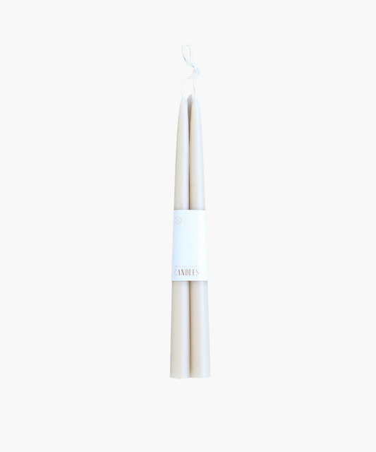 Two white tapered candles with a simple label reading "Candles." The image conveys a minimalistic and elegant aesthetic on a plain background. | SW Home.