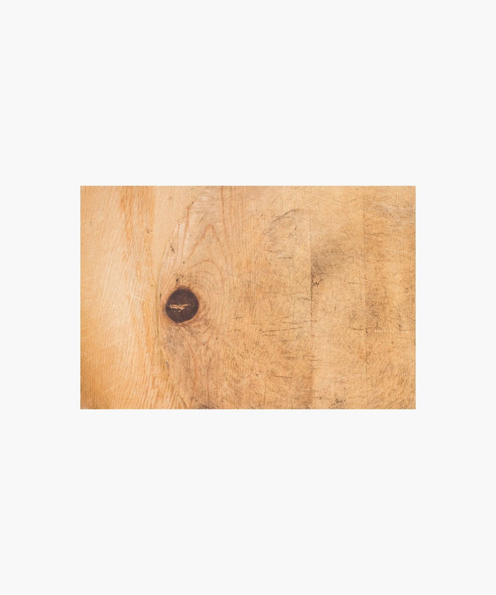 Cross section of a rustic, wooden cutting board with a worn texture suggests frequent use, conveying a homely, vintage feel.