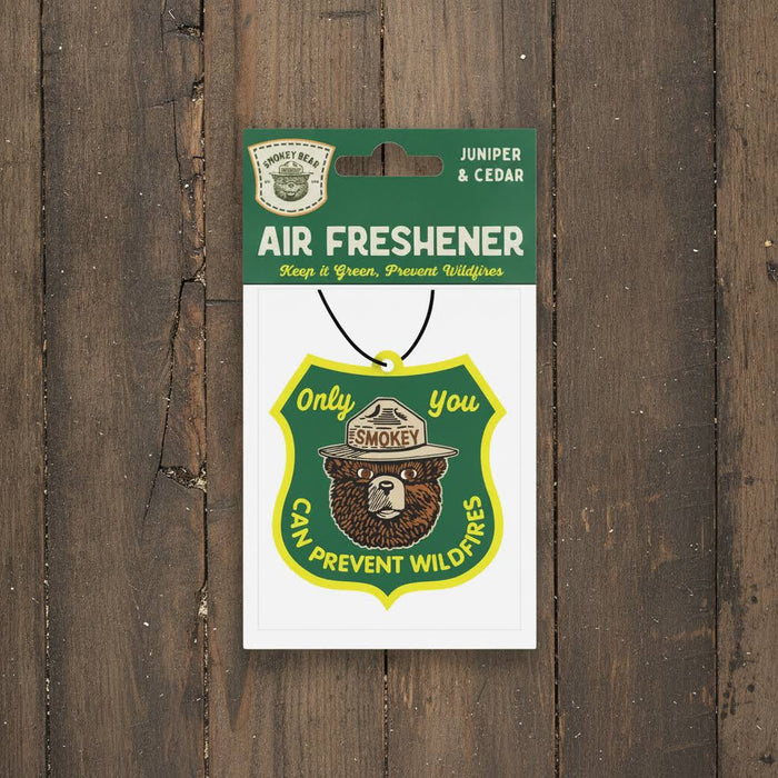 Forager Provisions LTD Smokey Bear hanging air freshener with Juniper and Cedar scent on a rustic wooden background.