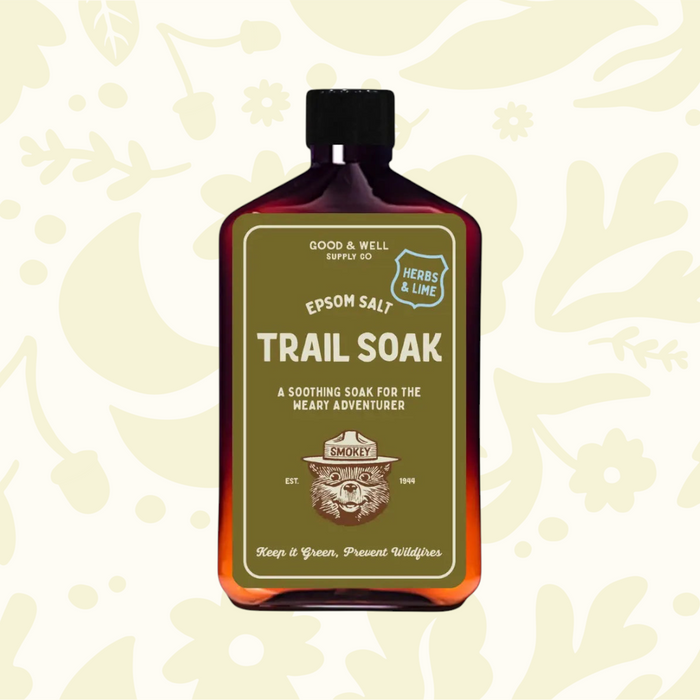 Forager Provisions LTD Good & Well Supply Co Smokey Bear Epsom Salt Trail Soak in an amber bottle with herbs and lime.