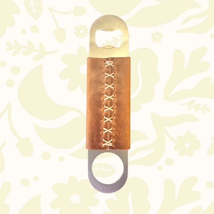Kjøtt Supply Co bar blade bottle opener with Horween leather grip, premium leather bar tool on white background.