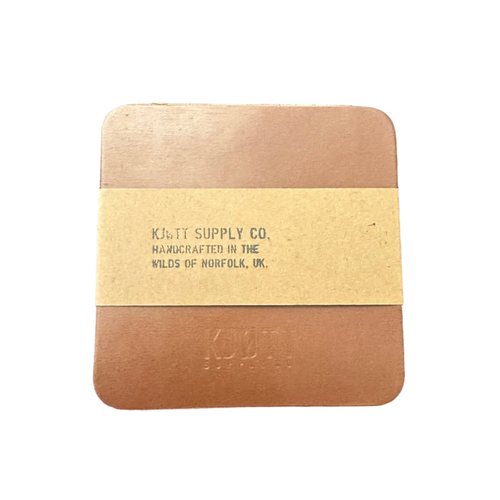 Forager Provisions LTD brown vegetable-tanned leather coasters with Kjøtt Supply Co. branding and paper wrap.