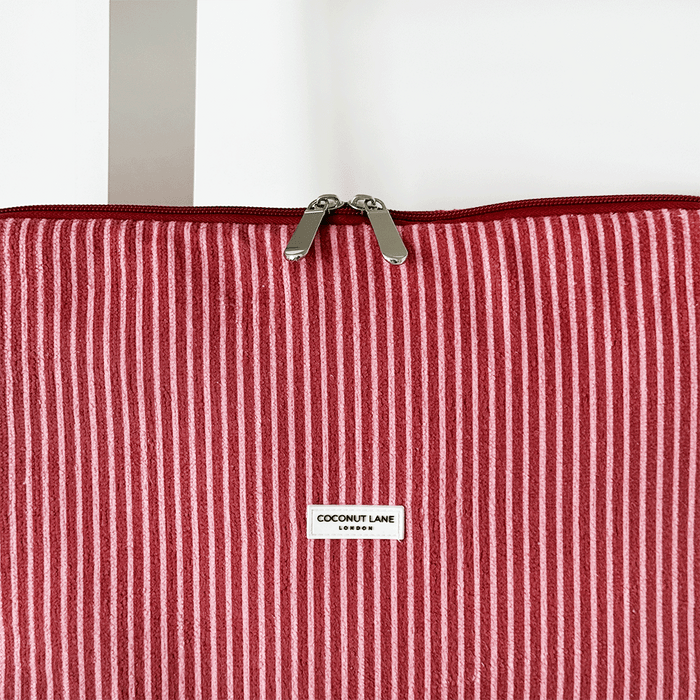 Red and white striped laptop sleeve with center label and zipper, displayed on a white background.