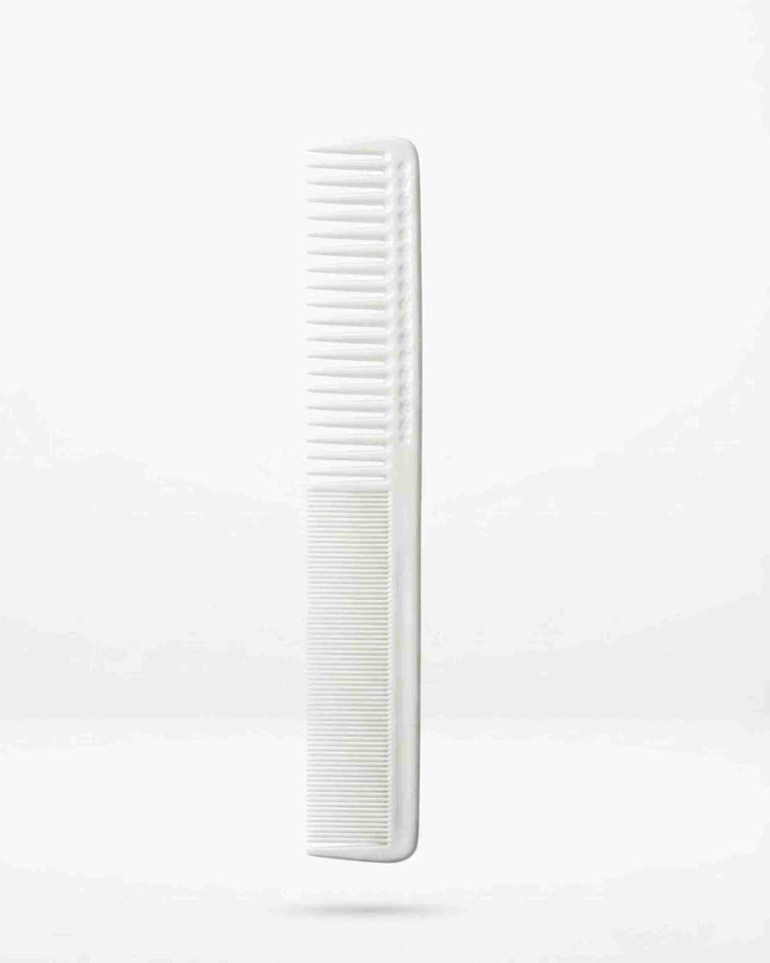 White long hair comb with fine teeth, vertical close-up