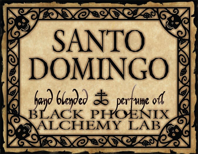 Label for Santo Domingo hand blended perfume oil by Black Phoenix Alchemy Lab with decorative border.