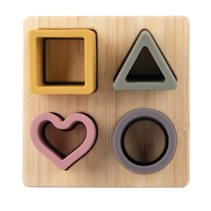 The Silicone Puzzle Toy features four colorful shape cutouts—a yellow square, gray triangle, pink heart, and purple circle—each fitting into its slot to help develop hand-eye coordination and cognitive skills.
