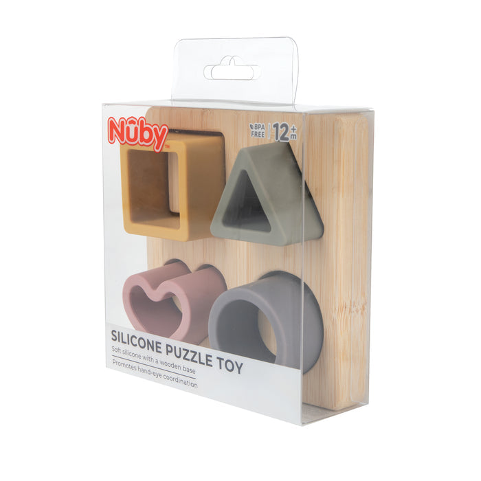 The Silicone Puzzle Toy is a soft, colorful baby puzzle set for ages 12+ months with four geometric shapes and a wooden base. It supports hand-eye coordination and cognitive development. Comes packaged in a clear box.