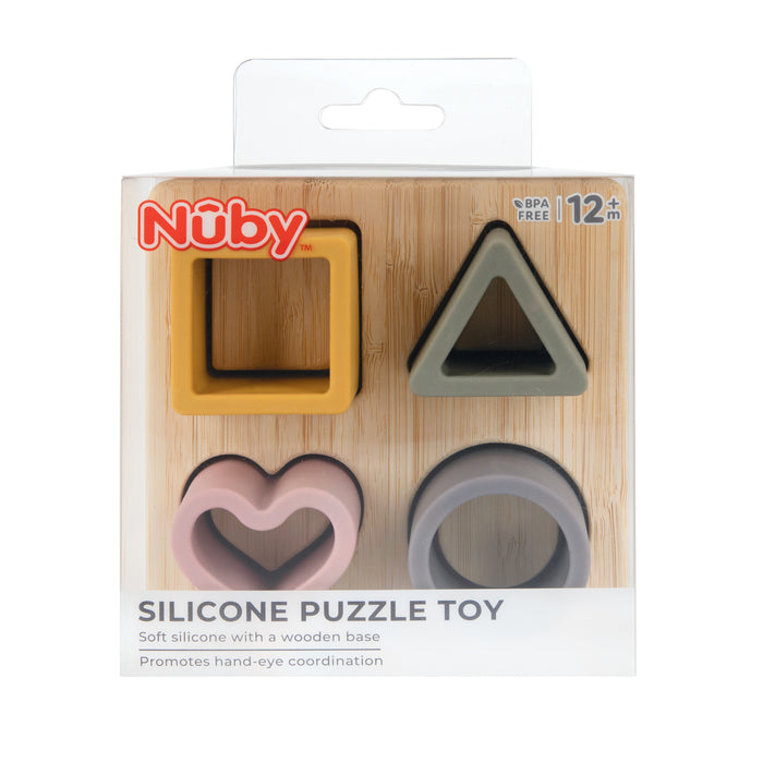 The Silicone Puzzle Toy is a soft silicone baby toy for ages 12+ months, with four colorful shapes (square, triangle, heart, circle) on a wooden base to promote hand-eye coordination and cognitive development.