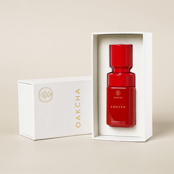 Front view of Sweven Perfume Oil bottle in red lacquer inside white presentation box showing gold Oakcha logo and 20 ml marking on beige background