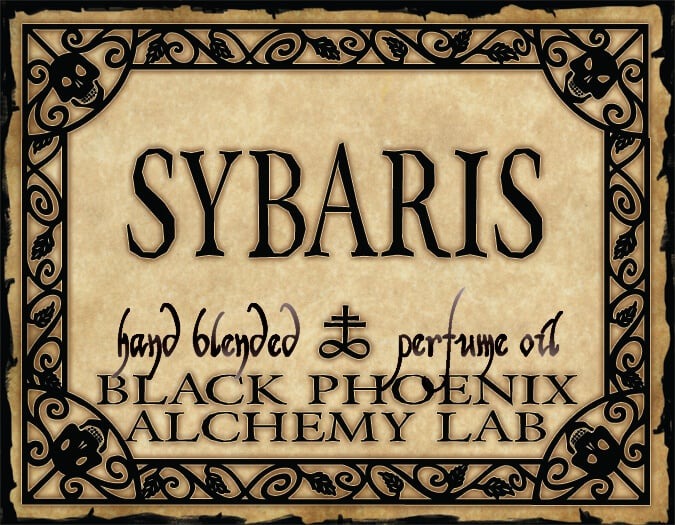Label for Sybaris hand blended perfume oil by Black Phoenix Alchemy Lab with decorative border.