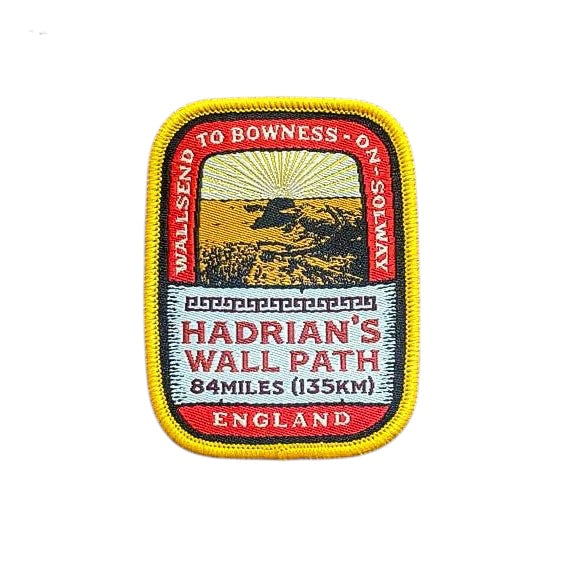Forager Provisions LTD embroidered Hadrian’s Wall Path patch with Roman ruins design on a rustic wooden background.