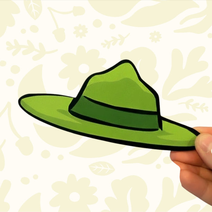 Forager Provisions LTD forest warden hat wooden sign in ranger green, held by hand against a floral background.