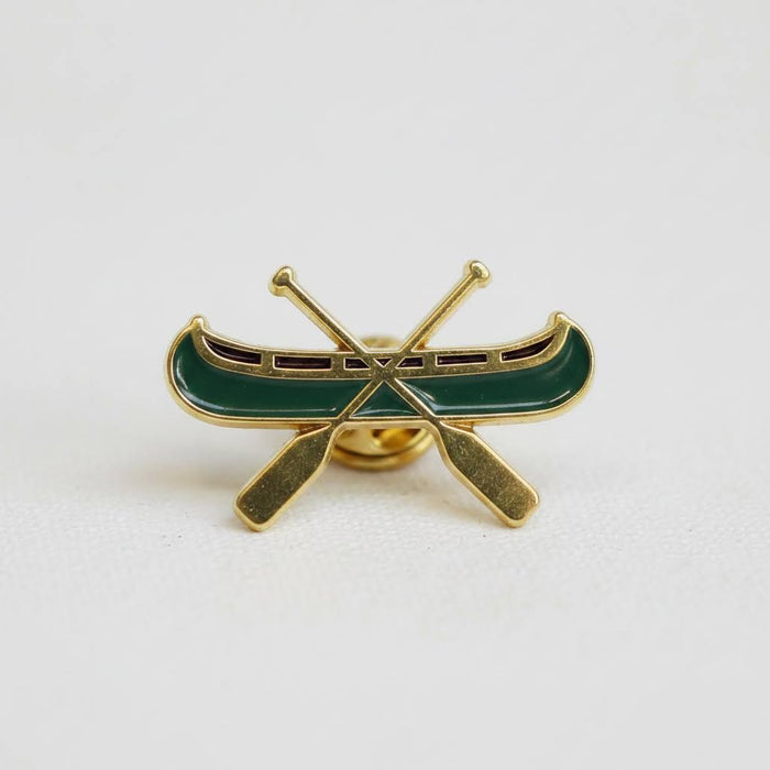 Forager Provisions LTD The Wild Wander canoe enamel pin in green and gold with crossed paddles design.