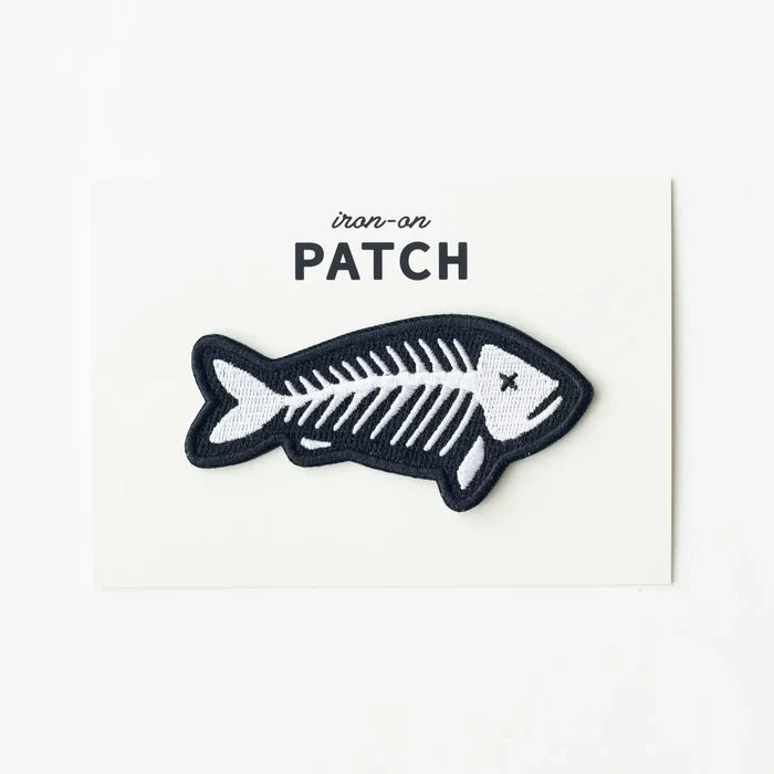 Union Made embroidered fish skeleton patch, black outline on white card labeled PATCH. High-quality union made brand patch.