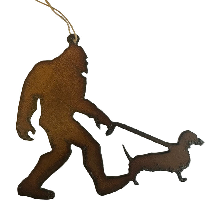 Forager Provisions LTD iron hanging decoration featuring a silhouette of Bigfoot walking a sausage dog on a leash.