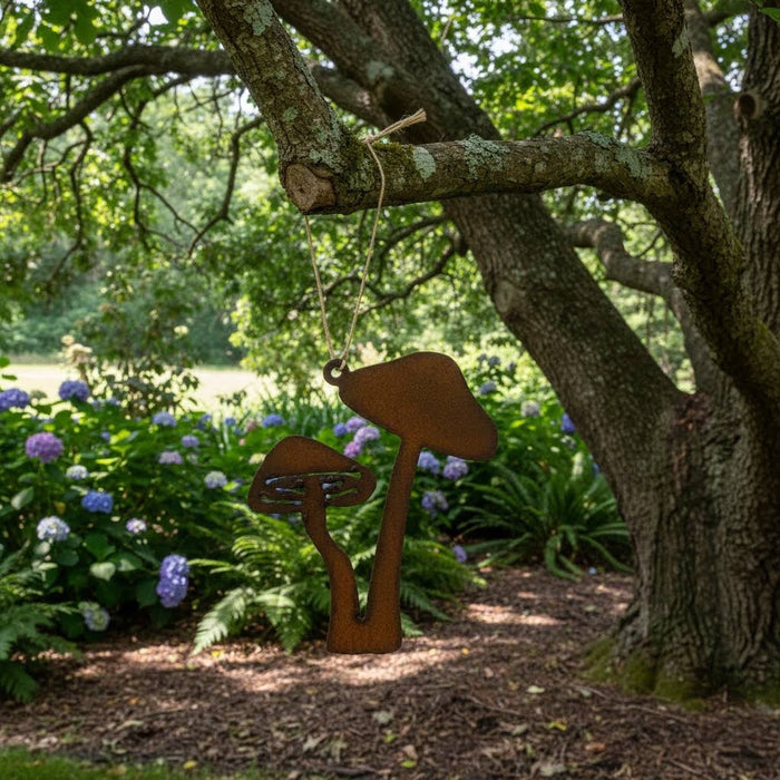 Forager Provisions LTD double mushroom iron hanging ornament with a natural rust finish hanging from a tree branch.