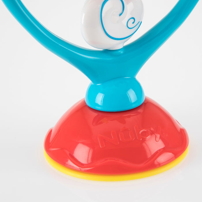 A close-up of the Whirly Wings interactive baby toy, featuring a red and yellow Nûby suction base, blue stem, and white spiral top detail—designed to encourage sensory development—shown against a white background.