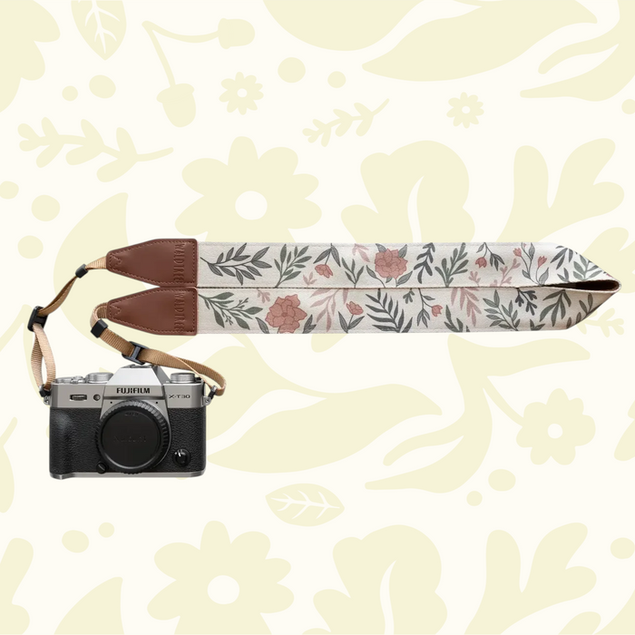 Forager Provisions LTD Wildtree Moody Flower camera strap with floral print, brown faux leather ends, and Fujifilm camera.