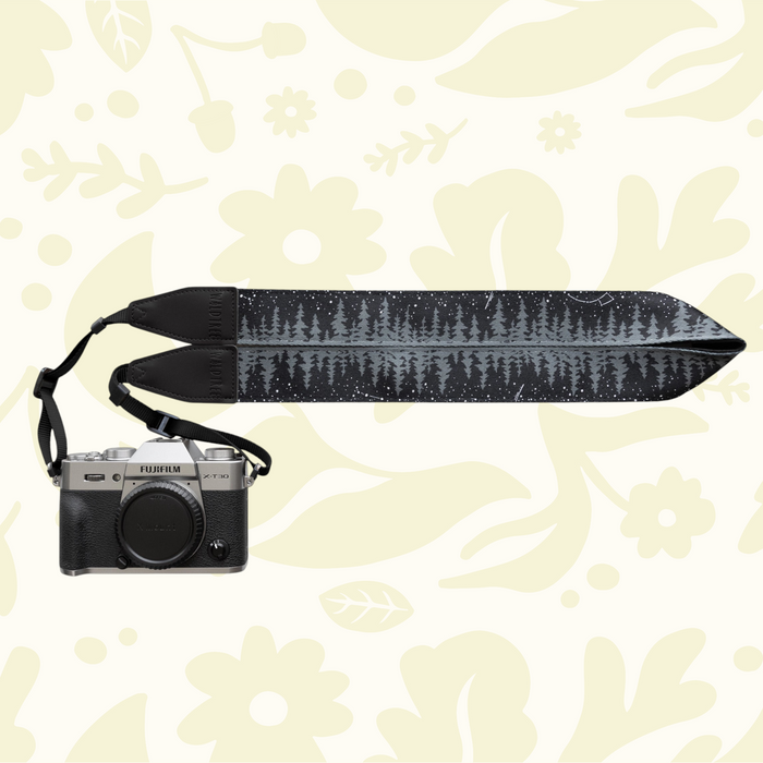 Forager Provisions LTD Wildtree Night Sky camera strap with a forest and star pattern attached to a silver Fujifilm camera