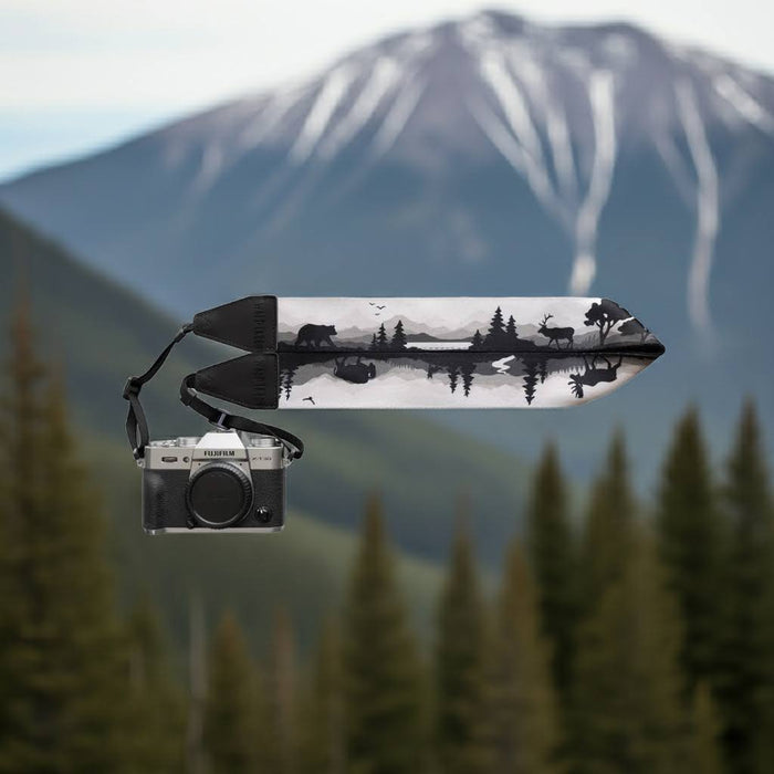 Forager Provisions LTD Wildtree camera strap featuring forest animal illustrations against a mountain landscape background